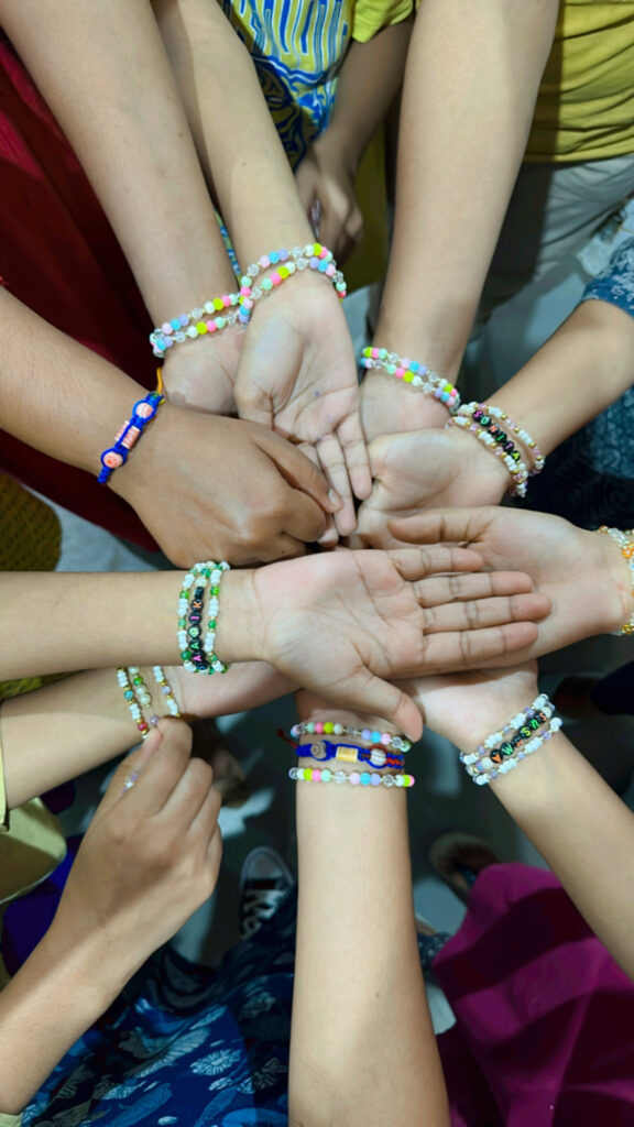 house of peace hands stretched out with friendship bracelets.