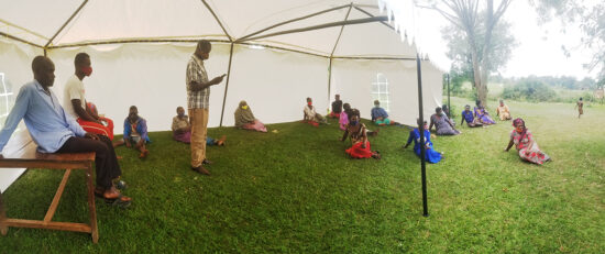 temporary tent provides some shade for patients waiting at the village medical center in uganda