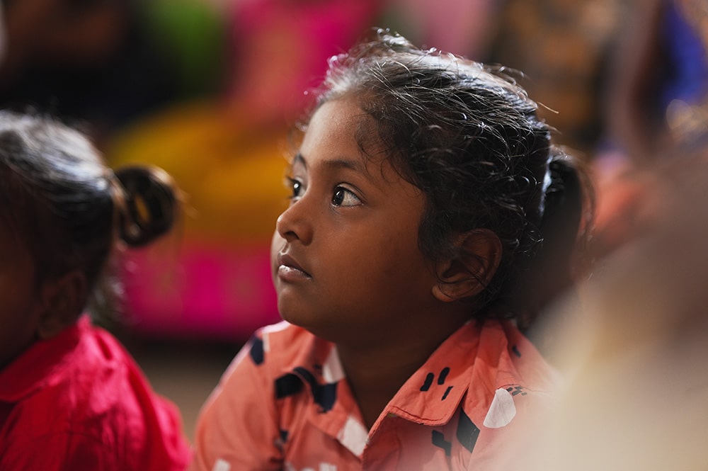 girl watching teacher at Irula Children's Center