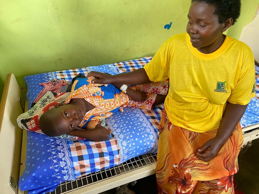 Elizabeth sitting with her son Lawrence, getting treatment at the medical clinic.