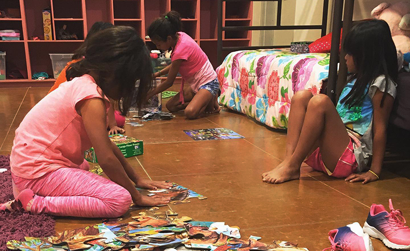 children from Rancho Los Amigos doing puzzles on the ground